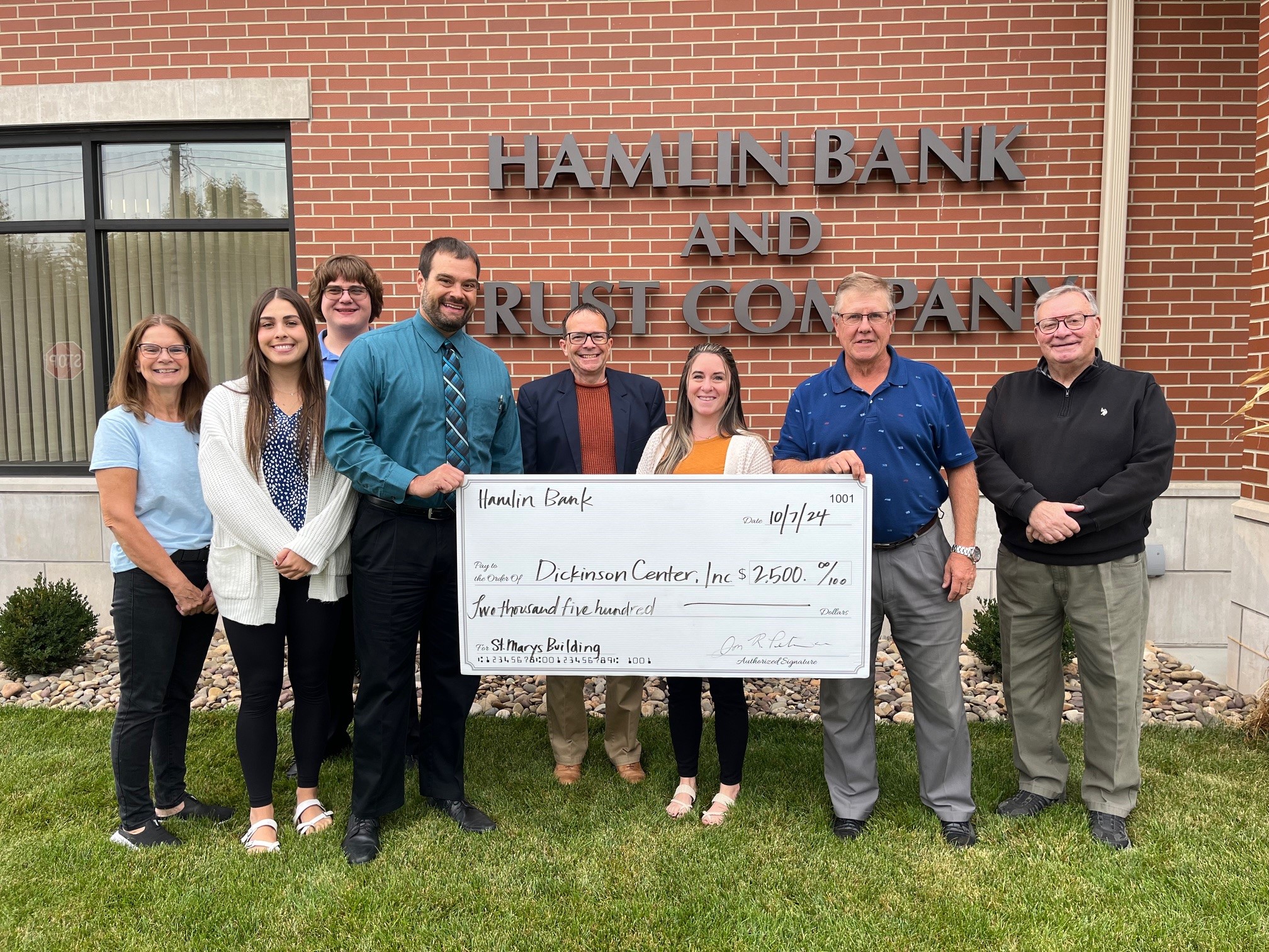 Photo of Hamlin Bank & DCI Representatives with donation check in front of Hamlin Bank St. Marys location